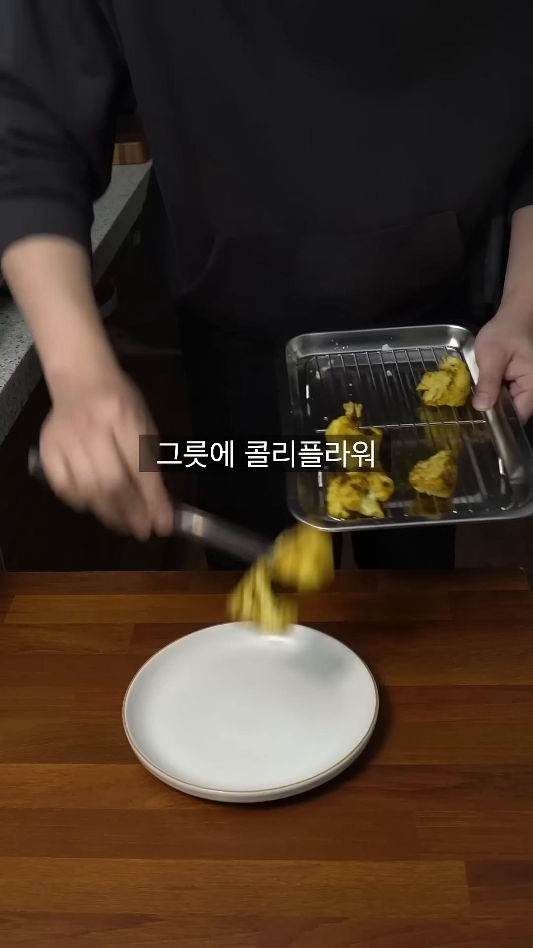그릇에 구운 콜리플라워를 담고 마라소스를 뿌린 후 치즈를 갈아 올리고 후추로 마무리합니다.